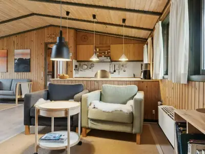 a living room with two chairs and a table at Charming Wooden Summer House In Trend in Løgstør