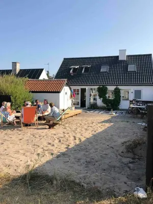 a group of people sitting in chairs on the beach at In Cold Hawaii With Beach In Backyard in Torsted