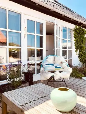 a chair and a vase on a wooden table at In Cold Hawaii With Beach In Backyard in Torsted
