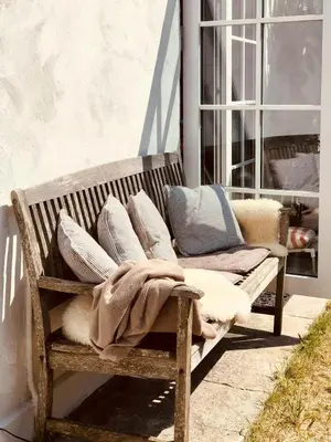 a wooden bench with pillows and a blanket on it at In Cold Hawaii With Beach In Backyard in Torsted