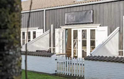 a house with a white fence in front of it at Cozy Home In Vestervig With Sauna in Vestervig