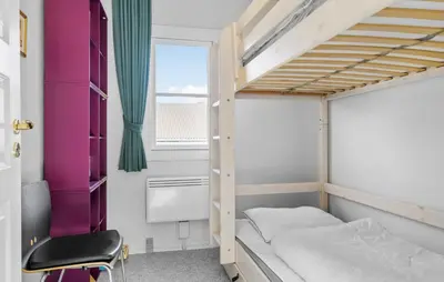 a bedroom with a bunk bed and a chair at Cozy Home In Vestervig With Sauna in Vestervig