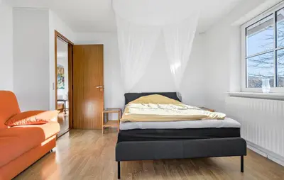 a bedroom with a bed and a couch at Beautiful Home In Nibe With Sauna in Nibe