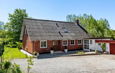 a red brick house with a gravel driveway at Beautiful Home In Nibe With Sauna in Nibe