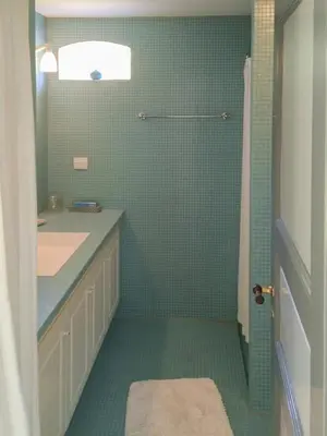 a bathroom with a sink and a shower with green tiles at Romance And Sea View At Havbakken in Fjerritslev