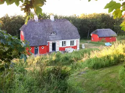 a red and white house and a barn in a field at Romance And Sea View At Havbakken in Fjerritslev