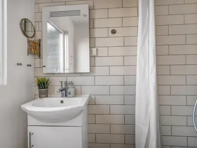 a white bathroom with a sink and a mirror at Holiday Home Alrike - 200m from the sea by Interhome in Brovst