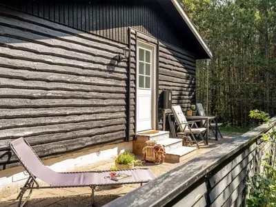 a house with a deck with chairs and a table at Holiday Home Hansa - 3km from the sea by Interhome in Blokhus