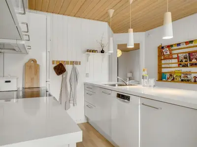 a white kitchen with white cabinets and a sink at Holiday Home Toska - 3km from the sea by Interhome in Blokhus