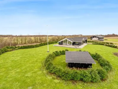 a house with a solar panel on a green field at Holiday Home Antero - 500m to the fjord by Interhome in Spottrup