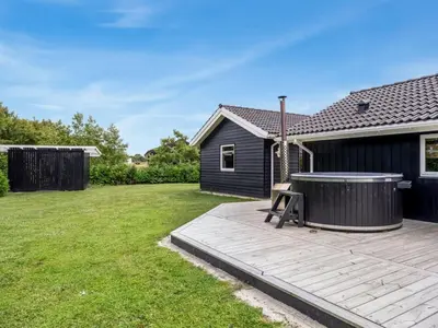 a backyard with a hot tub and a house at Holiday Home Antero - 500m to the fjord by Interhome in Spottrup