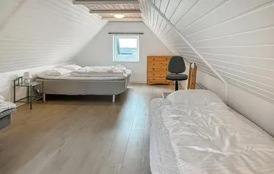 a attic bedroom with two beds and a chair at Gorgeous Home In Thisted With Wifi in Thisted