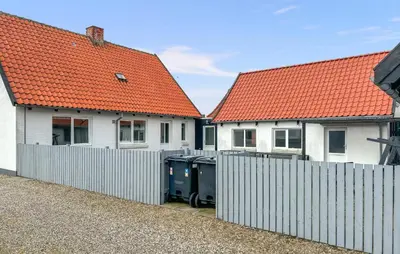 two houses with orange roofs and a fence with trash cans at Gorgeous Home In Thisted With Wifi in Thisted