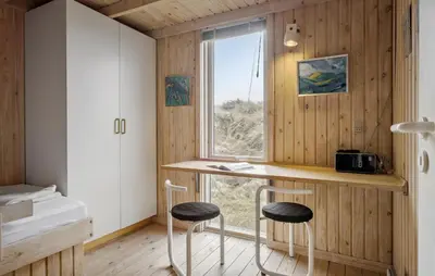 a room with a desk and two stools and a window at Cozy Home In Saltum With House Sea View in Saltum