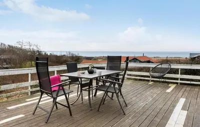 a table and chairs on a deck with the ocean at 3 Bedroom Amazing Home In Spøttrup in Spottrup