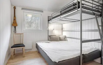 a bedroom with a bunk bed and a chair at 3 Bedroom Amazing Home In Spøttrup in Spottrup