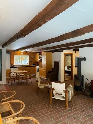 a living room with tables and chairs and a stove at Unique location in Thy in Thisted
