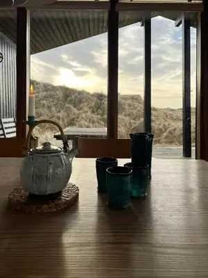 a tea kettle sitting on a table with a view at Wooden House In The Dunes Close To The Sea in Pandrup