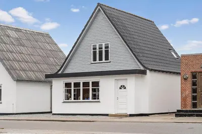 a white house with a gambrel roof at Newly renovated house in the center in Thyborøn