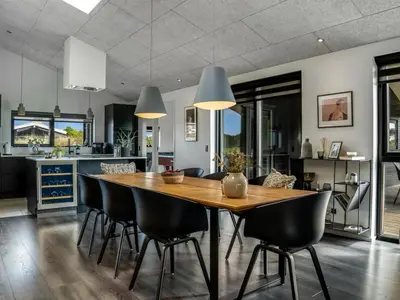 a kitchen and dining room with a wooden table and chairs at Holiday Home Eriksine - 750m from the sea by Interhome in Løkken