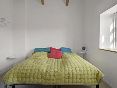 a bedroom with a bed with a yellow comforter at Holiday Home Amina - 200m from the sea by Interhome in Blokhus