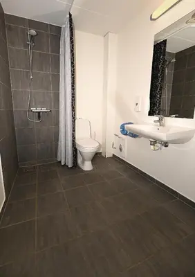 a bathroom with a toilet and a sink at Sport & Academy in Farsø