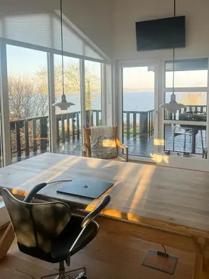 a table with a laptop on top of it in a living room at Architect-Designed House With Private Beach in Løgstrup
