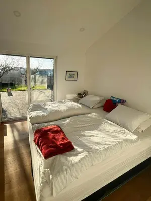 a bedroom with two beds and a large window at Architect-Designed House With Private Beach in Løgstrup