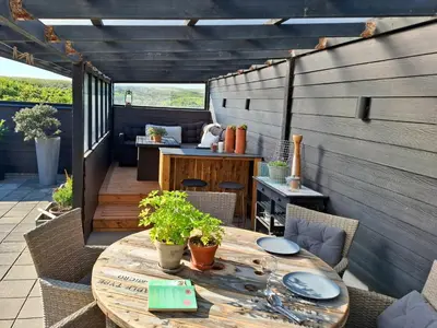 an outdoor patio with a wooden table and chairs at Charming Town House In Thyborøn Near The North Sea in Thyborøn