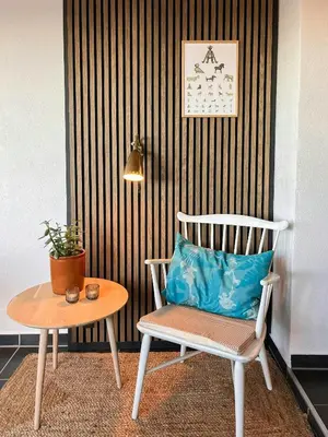 a chair with a blue pillow sitting next to a table at Charming Town House In Thyborøn Near The North Sea in Thyborøn