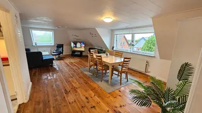 a dining room and living room with a table and chairs at Nattely i Thy in Thisted
