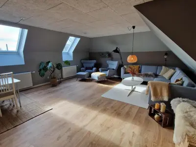 a living room with a couch and a table at Stædets lejlighed in Bøvlingbjerg