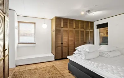a bedroom with a bed with white pillows at 5 Bedroom Nice Home In Blokhus in Blokhus