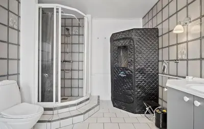 a black and white bathroom with a shower and a toilet at 5 Bedroom Nice Home In Blokhus in Blokhus