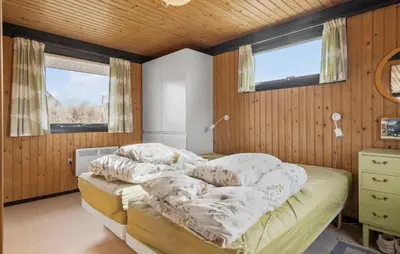a bedroom with a bed and two windows at 5 Bedroom Lovely Home In Saltum in Saltum
