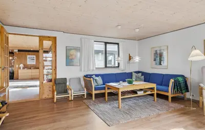 a living room with a blue couch and a table at 5 Bedroom Lovely Home In Saltum in Saltum