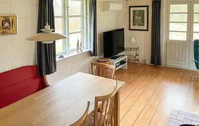a living room with a table and a red couch at Stunning Home In Øster Assels With Wifi in Øster Assels