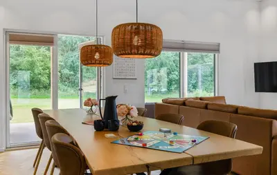 a dining room with a wooden table and chairs at Lovely Home In Spøttrup With Sauna in Spottrup