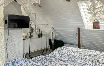 a bedroom with a bed and a flat screen tv at 2 Bedroom Beautiful Home In Vinderup in Vinderup