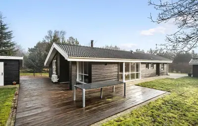 a house with a bench on a wooden deck at Lovely Home In Fjerritslev With Sauna in Fjerritslev