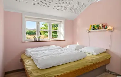 a bedroom with a bed with white sheets and a window at Cozy Home In Spøttrup With Wifi in Lihme