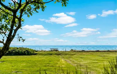 a park with a bench in front of the ocean at Cozy Home In Spøttrup With Wifi in Lihme