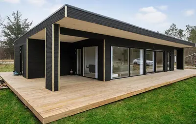 a black house with a wooden deck at 3 Bedroom Awesome Home In Fjerritslev in Fjerritslev