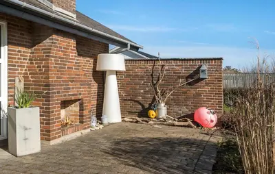 a brick wall with a lamp next to a house at Amazing Home In Thyborøn With Sauna in Thyborøn