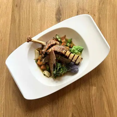 a white bowl of food with meat and vegetables at Hotel Thisted in Thisted