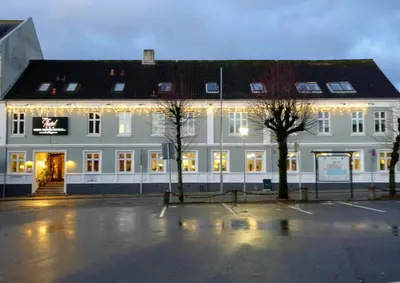 a large white building with christmas lights on it at Hotel Thisted in Thisted