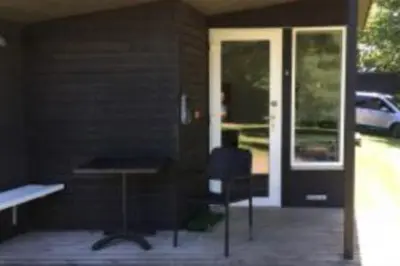a person sitting at a table in front of a door at Holstebro Søpark in Holstebro
