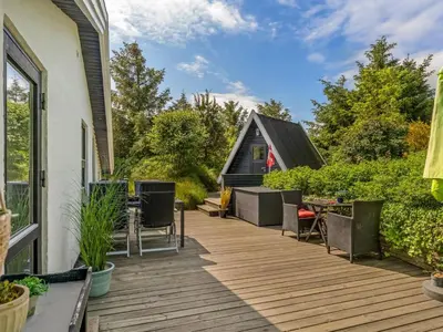 a deck with chairs and a small cabin at Holiday Home Annemone - 900m from the sea by Interhome in Blokhus