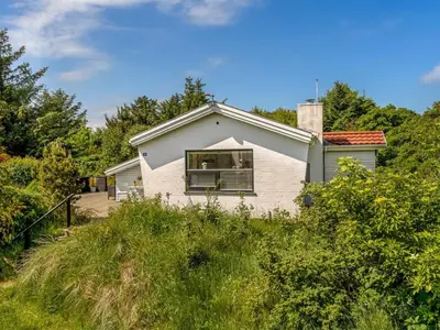 a white house on a hill with trees at Holiday Home Annemone - 900m from the sea by Interhome in Blokhus