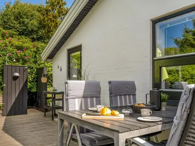 a patio with a table and chairs on a deck at Holiday Home Annemone - 900m from the sea by Interhome in Blokhus
